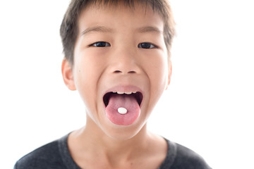 Close up white pill on boy tongue