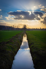 Sunset with water ditch between fields in the Lüneburger Heide, Northern Germany.