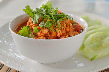 Close up delicious Northern Thai meat and tomato spicy dip in white bowl served with slice cucumber