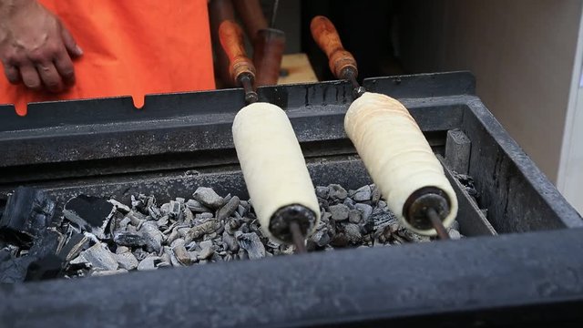 Trdelnik on the charcoal grill being prepared at the street bakery in Budapest, Hungary. Traditional czech sweet treat.