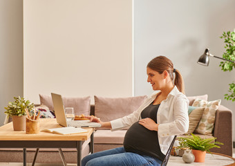 Pregnant woman is working hard at the office or home style.