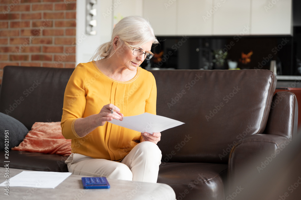 Wall mural senior woman with calculator and bills counting