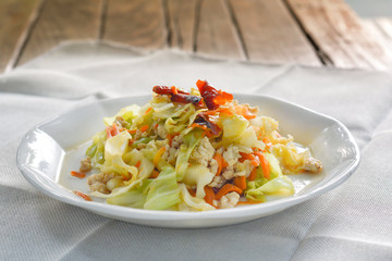 stir fried cabbage  with mince chicken breast, red dried chili, slice carrots on white dish for served with rice. Thai delicious food for dinner.