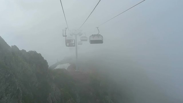 Open-type cable car in fog over mountains