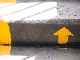 Yellow arrow paint on oncrete stair background