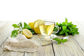 Mint tea and lemons on a wooden table close-up