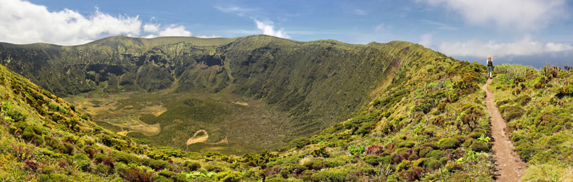 Women is hiking along the crater rim of Caldeira of Faial, Azores