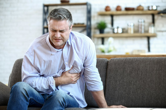 Handsome mature man having heart attack at home