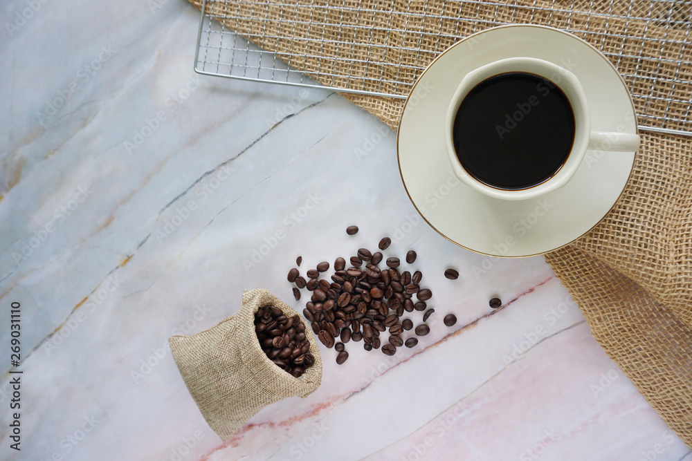 Wall mural cup of coffee, bag and beans on a marble textured background.