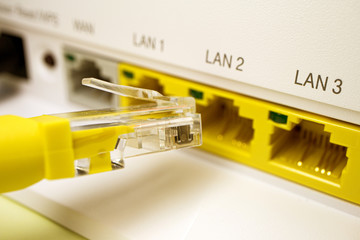 white router for home Internet with yellow ports for subscribers from which the yellow patch cord