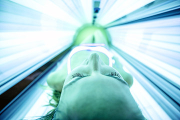 Woman getting tanned in sunbed