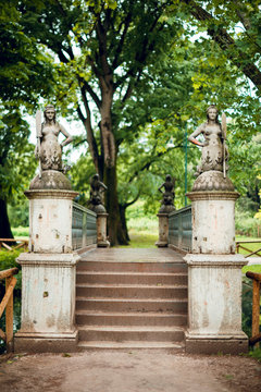 Stone bridge with mermaids sculptures in the beautiful green park Sempione in Milan Italy.