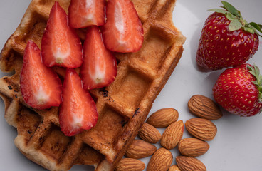 Homemade waffles with berry and nuts on white background. Sweet dessert. Delicious food