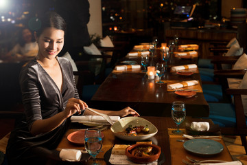 Asian Beautiful Woman have Dinner in luxury roof top restaurant with secret recipe Menu on plate course set of Spanish food Cuisine culinary which a bit hot and unique taste on wooden table.