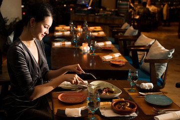 Asian Beautiful Woman have Dinner in luxury roof top restaurant with secret recipe Menu on plate course set of Spanish food Cuisine culinary which a bit hot and unique taste on wooden table.