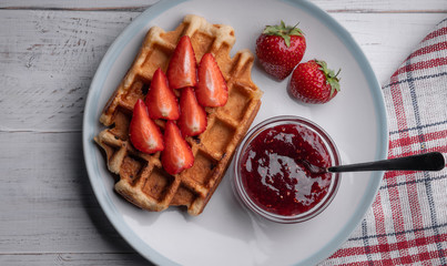 Homemade belgian waffles with strawberry and jam on the white table. Top view. Delicious. Dessert. Sweet food