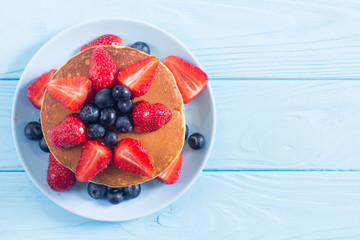 Tasty pancakes with blueberry and strawberry