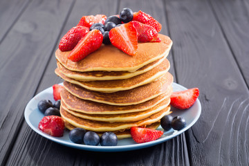 Tasty pancakes with blueberry and strawberry