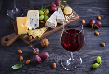 Red wine with cheese on chopping board. Wine and food concept - Image