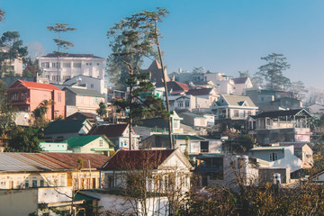 Houses on the hill cover by morning fog and sunlight in Da Lat, Vietnam