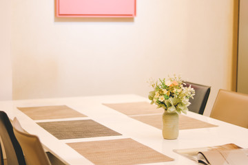 Flower in a vase on table in an modern,elegant dining room.