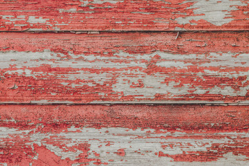 Сracked paint on wood vintage texture. Painted old wooden red wall background. Wooden grunge background