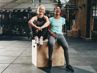 Two young women laughing after working out at the gym