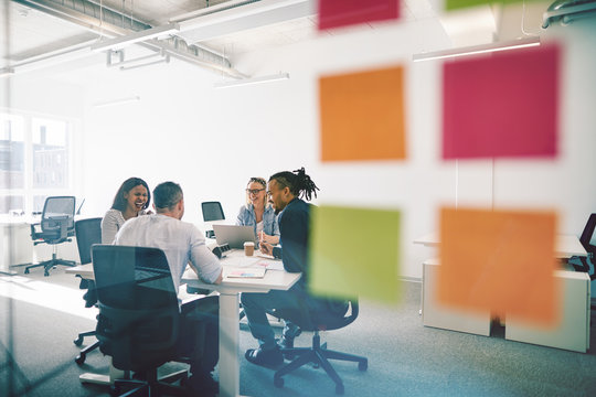 Diverse Colleagues Meeting Together Inside Of A Glass Walled Off