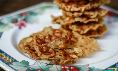 Peanut Peyek on plate. Peanut Rempeyek or Peyek is a deep-fried savoury Javanese cracker made from  rice flour with peanut by crispy flour batter. Indonesian food.