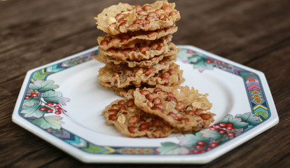 Peanut Peyek on plate. Peanut Rempeyek or Peyek is a deep-fried savoury Javanese cracker made from  rice flour with peanut by crispy flour batter. Indonesian food.