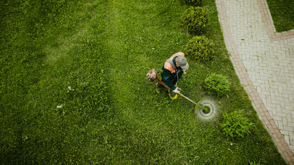the lawnmower man mows the lawn the view from the top - obrazy, fototapety, plakaty
