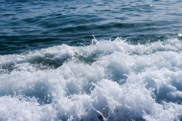 Obraz premium White Foam Of Sea Waves, Splashes Ashore. Blue Sky. Hot Summer.