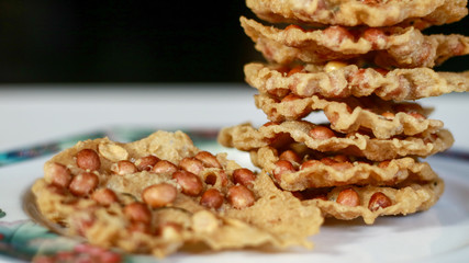 Peanut Peyek on plate. Peanut Rempeyek or Peyek is a deep-fried savoury Javanese cracker made from  rice flour with peanut by crispy flour batter. Indonesian food.