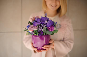 Young woman holding irises in flower pot