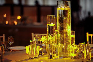 table set by burning candles glasses