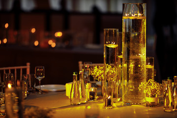 table set by burning candles glasses
