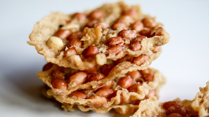 Peanut Peyek on white background. Peanut Rempeyek or Peyek is a deep-fried savoury Javanese cracker made from  rice flour with peanut by crispy flour batter. Indonesian food.