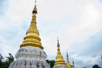 Fototapeta premium Many golden pagodas on the courtyard of temple in northern thailand, with blue sky background.