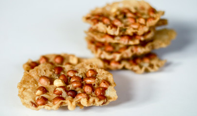 Peanut Peyek on white background. Peanut Rempeyek or Peyek is a deep-fried savoury Javanese cracker made from  rice flour with peanut by crispy flour batter. Indonesian food.