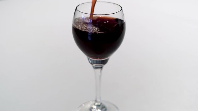 Das eingie&szlig;en eines Rotwein in ein Weinglas in 4K