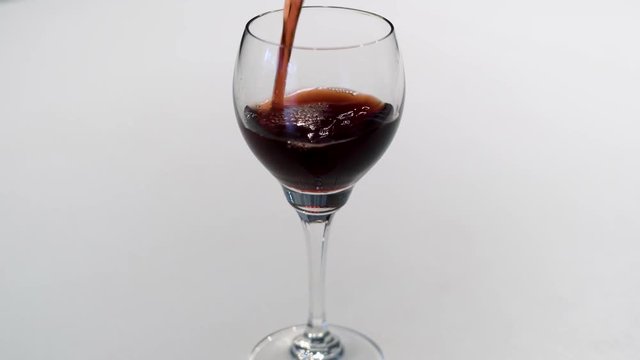 Das eingie&szlig;en eines Rotwein in ein Weinglas in 4K