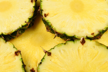 Pineapple juicy yellow slices background. Top view.