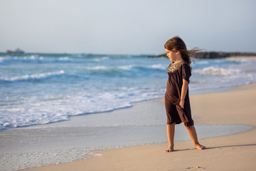 Young girl running along the beach in Dubai
