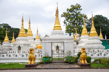 Fototapeta premium Many golden pagodas on the courtyard of temple in northern thailand, with blue sky background.