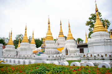 Fototapeta premium Many golden pagodas on the courtyard of temple in northern thailand, with blue sky background.