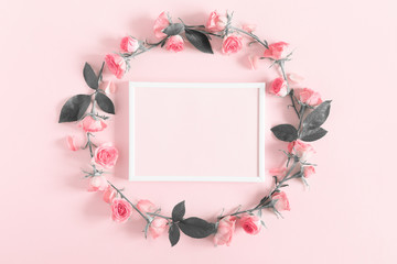 Beautiful flowers composition. Blank frame for text, pink rose flowers on pastel pink background. Flat lay, top view, copy space