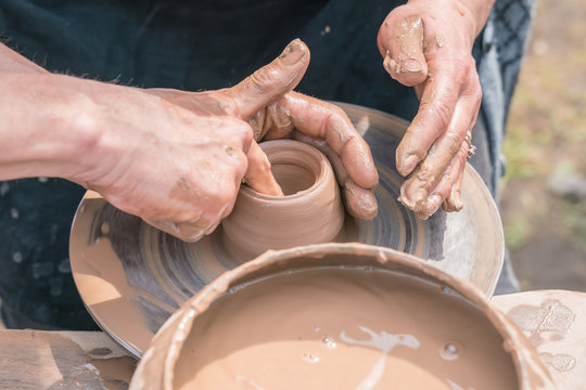Master teaching  pottery. Working with clay. Master ceramist teaches student. Craftsman hands making pottery bowl. 