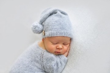 Sleeping newborn boy in the first days of life on white background