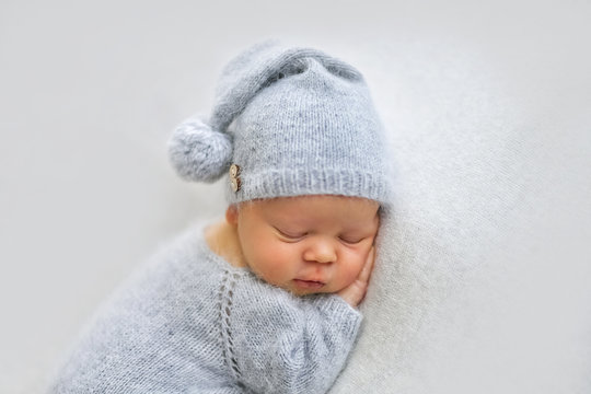Sleeping newborn boy in the first days of life on white background