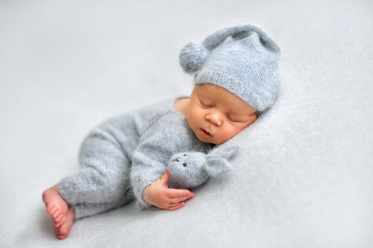 Sleeping newborn boy in the first days of life on white background